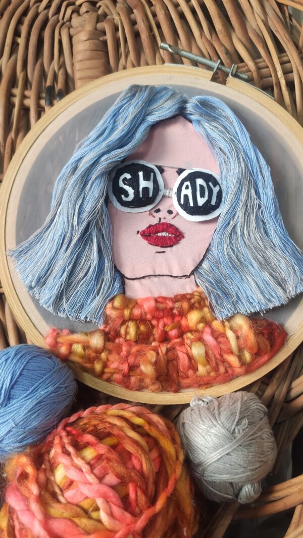 embroidered hoop art of a girl 3d hair with sunglasses written shady on it