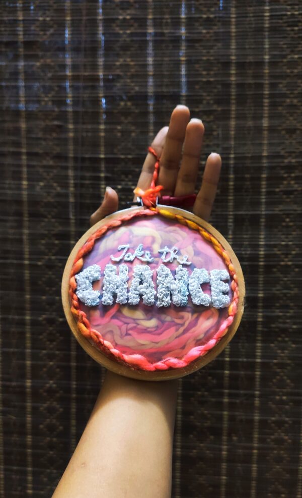embroidered hoop art with wool stuffed inside take the chance written